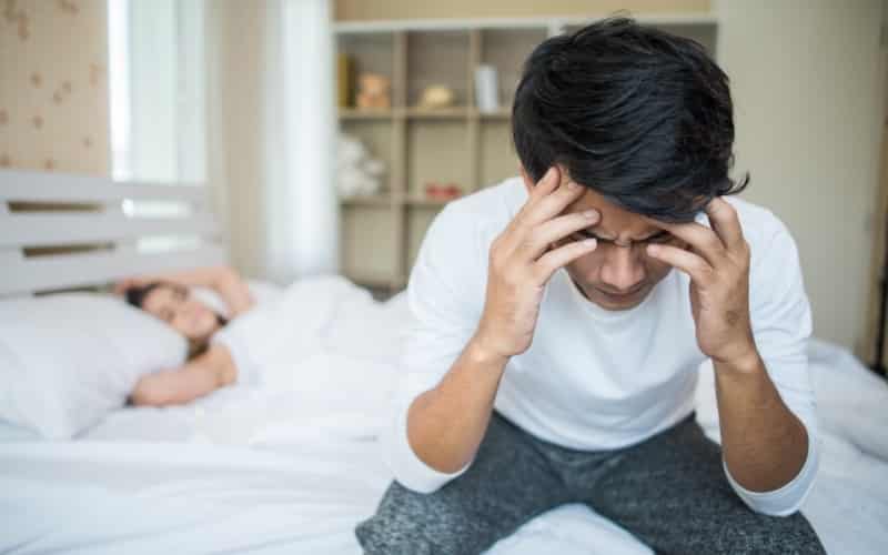 a disappointed couple sitting on bed